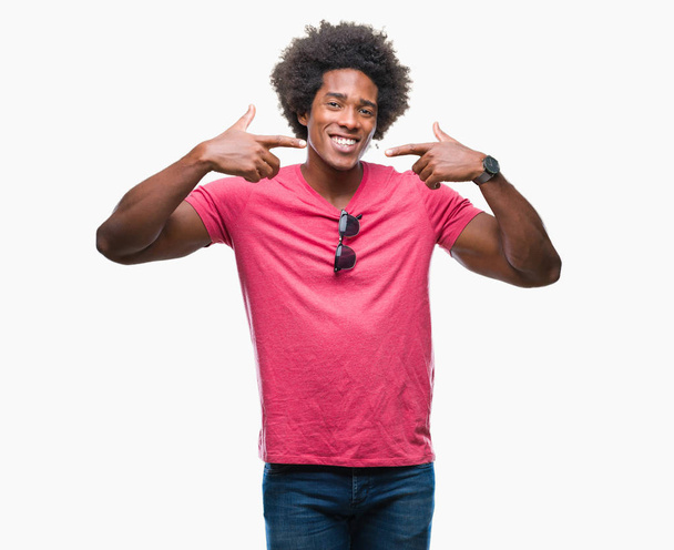 Kendinden emin gösterilen ve işaret parmakları diş ve ağız ile gülümseyen izole arka plan üzerinde Afro Amerikalı adam. Sağlık kavramı. - Fotoğraf, Görsel