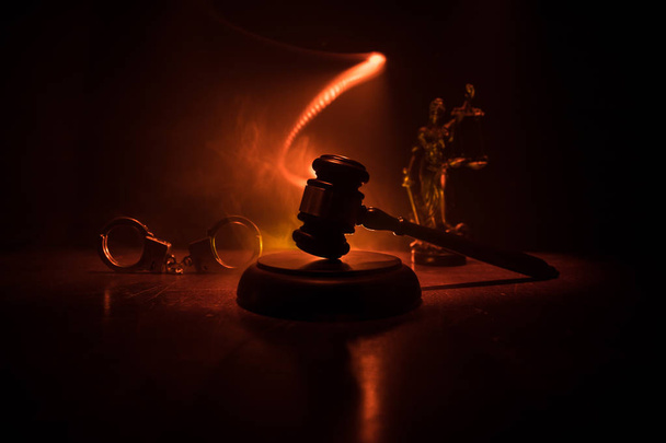Hukuk tema, hakimin adalet heykeli ile ahşap masa üzerinde çekiç. Işık ile karanlık sisli zemin üzerine hukuk tokmak. Seçici odak - Fotoğraf, Görsel