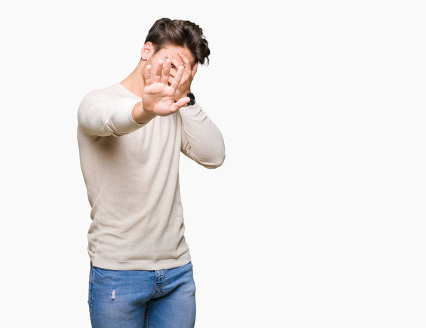 Young handsome man over isolated background covering eyes with hands and doing stop gesture with sad and fear expression. Embarrassed and negative concept. - Photo, Image