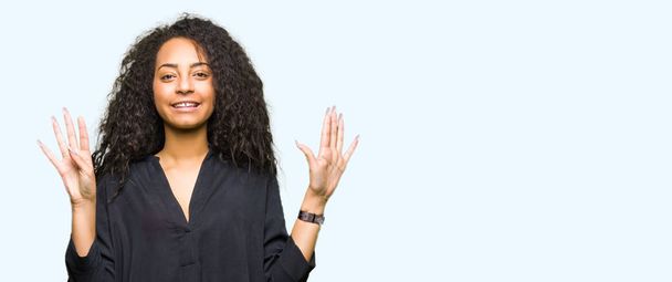 Young beautiful girl with curly hair wearing elegant dress showing and pointing up with fingers number nine while smiling confident and happy. - Photo, Image