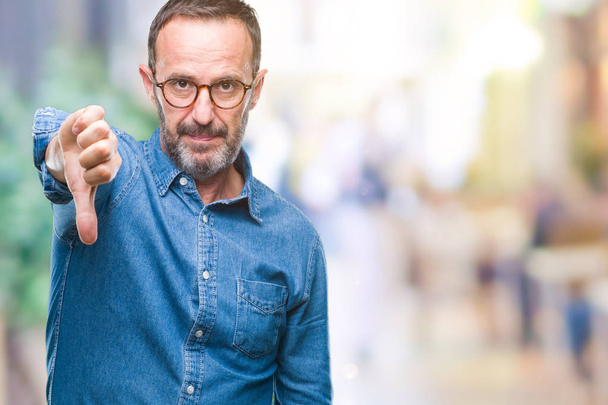 Middle age hoary senior man wearing glasses over isolated background looking unhappy and angry showing rejection and negative with thumbs down gesture. Bad expression. - Photo, Image