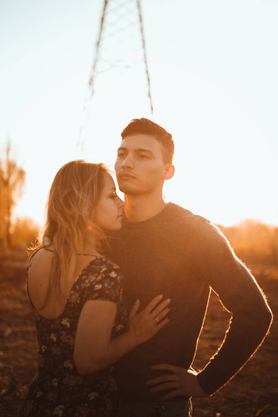 guy and girl in the field on the sunset background. - Photo, Image