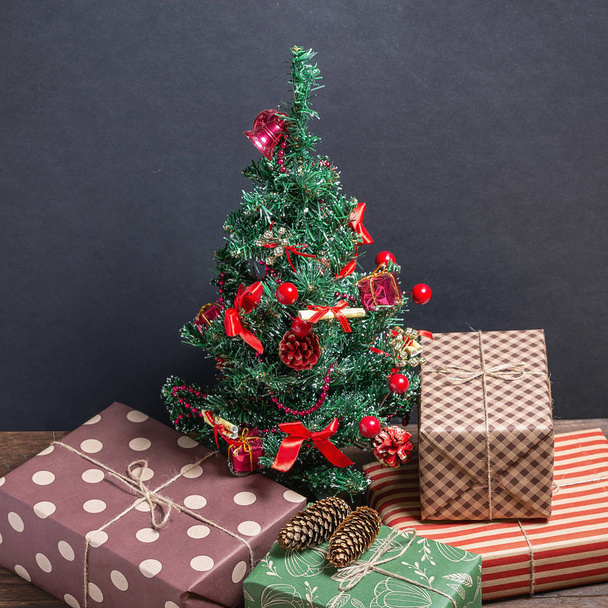 Varied and bright gifts under a Christmas tree on a black background - Photo, Image