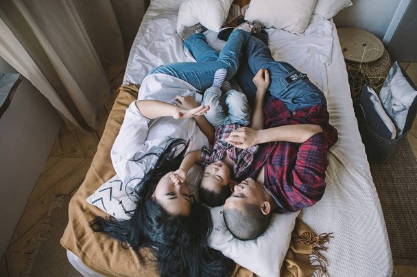 Корейської сім'ї з сином, лежачи на ліжку подушки - Фото, зображення