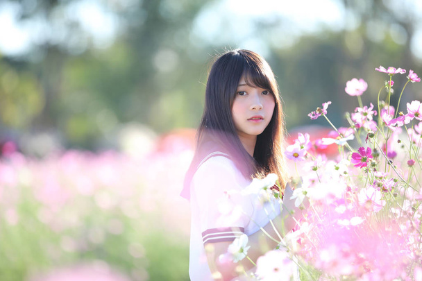 Japon liseli kız cosmos çiçek ile Tekdüzen portresi  - Fotoğraf, Görsel