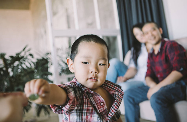 Close view of asian toddler boy with parents on background sitting on sofa - Photo, Image