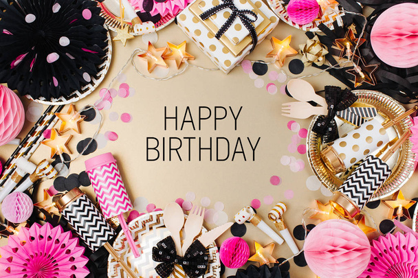 Top view shot with frame made of party decorations in in golden, black and pink colors. Happy Birthday text in the middle - Foto, afbeelding