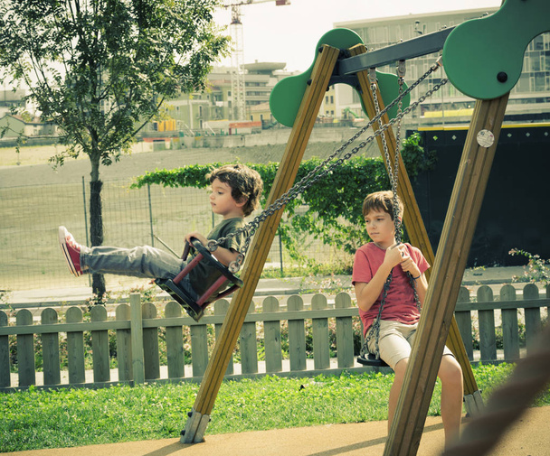 Hermanos jugando al aire libre en el centro de Milán en el otoño
 - Foto, imagen