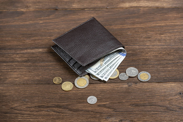 leather wallet with dollars on a wooden background - Foto, Bild