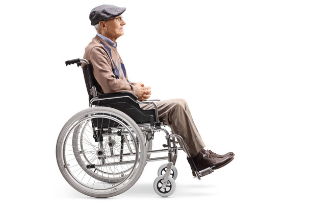 Volledige lengte profiel shot van een senior man in een rolstoel geïsoleerd op witte achtergrond - Foto, afbeelding