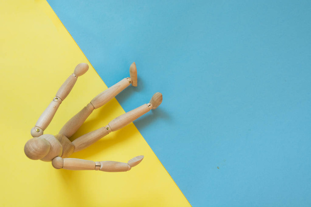 Wooden doll on yellow and blue. Concept beach sand and water. Travel. - Foto, afbeelding