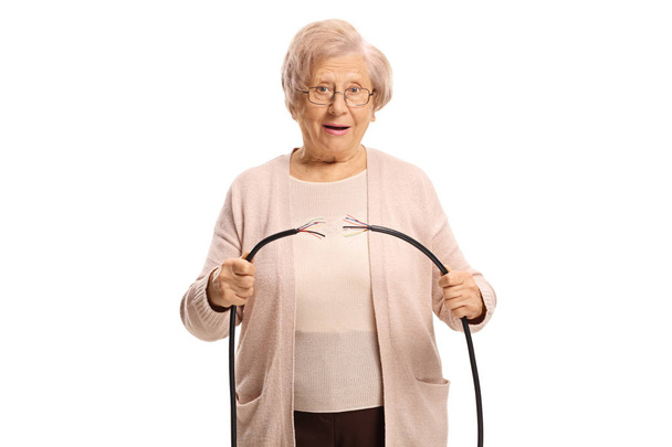 Senior woman holding a broken cable isolated on white background - Foto, imagen