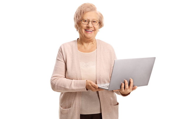 Happy senior woman holding a laptop computer isolated on white background - Foto, Imagem