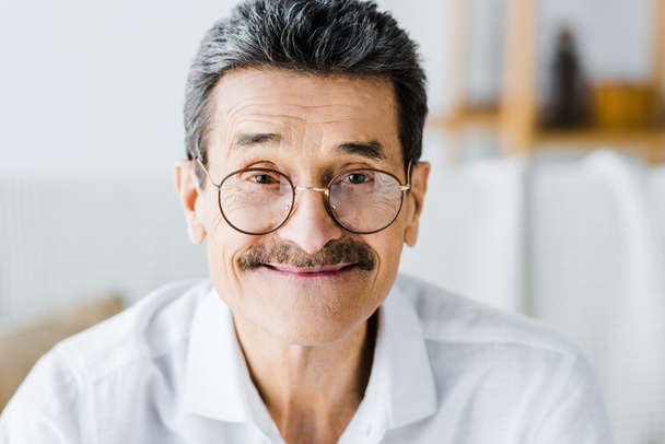 счастливый пожилой человек в очках улыбается дома
 - Фото, изображение