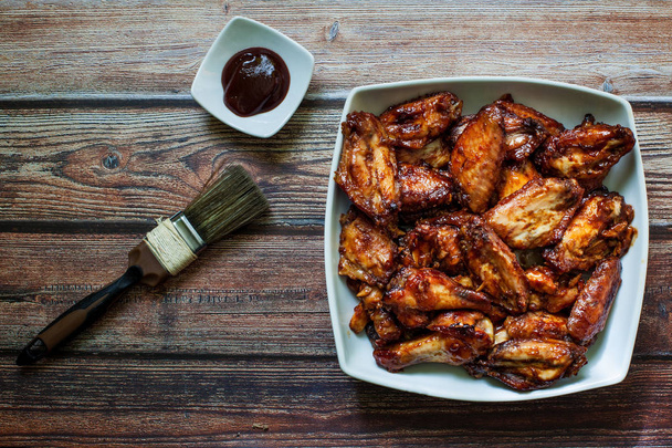 ali di pollo arrosto con salsa barbecue calda sulla ciotola
 - Foto, immagini