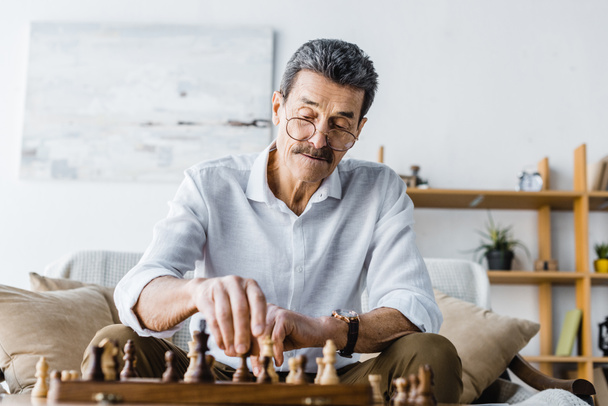 zamyślony starszy mężczyzna z wąsem, gra w szachy w domu - Zdjęcie, obraz
