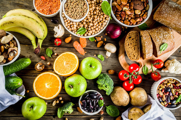 Zdrowe jedzenie. Wybór źródeł dobre węglowodany, błonnik potrawy. Dieta o niskim IG indeksu. Świeże warzywa, owoce, zboża, rośliny strączkowe, orzechy, warzywa. Drewniane tło - Zdjęcie, obraz