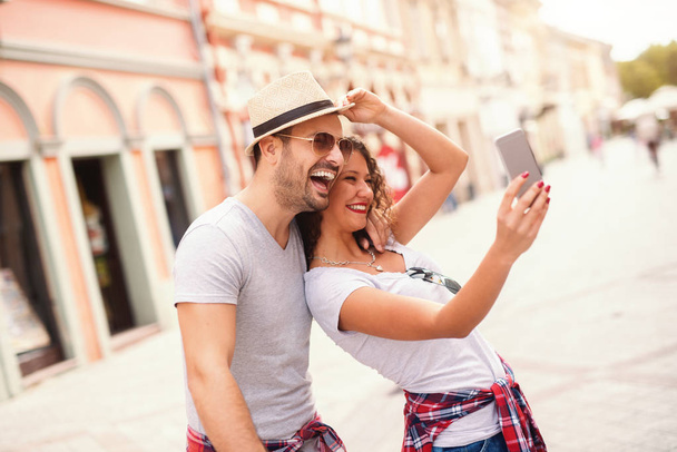 Szczęśliwa para biorąc selfie na ulicy na lato. Koncepcja podróży. - Zdjęcie, obraz