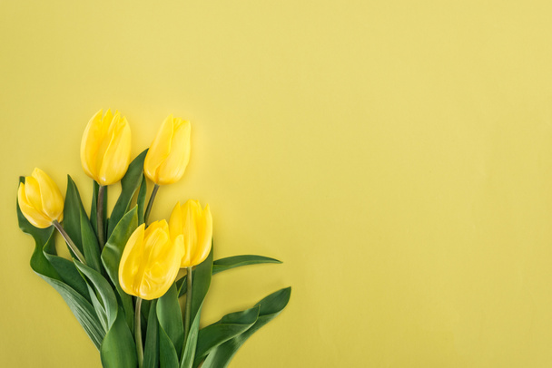 вид сверху букета с желтыми тюльпанами, изолированными на желтом
 - Фото, изображение