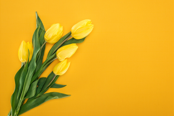 top view of bouquet with yellow tulips on orange background for 8 march - Fotografie, Obrázek