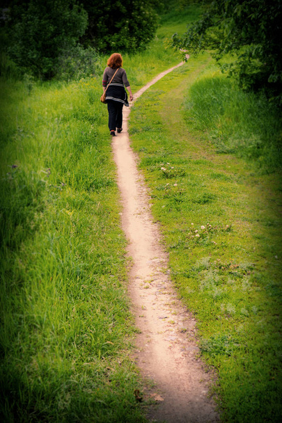 Woman travels along the path in the village - Φωτογραφία, εικόνα