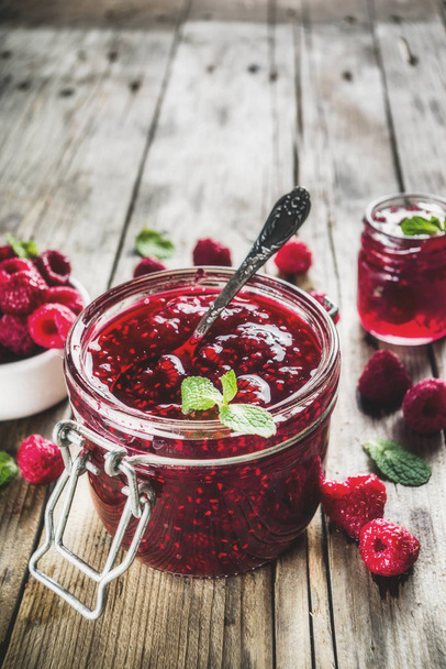 Homemade raspberry jam in two jars with raspberries and mint - Photo, Image