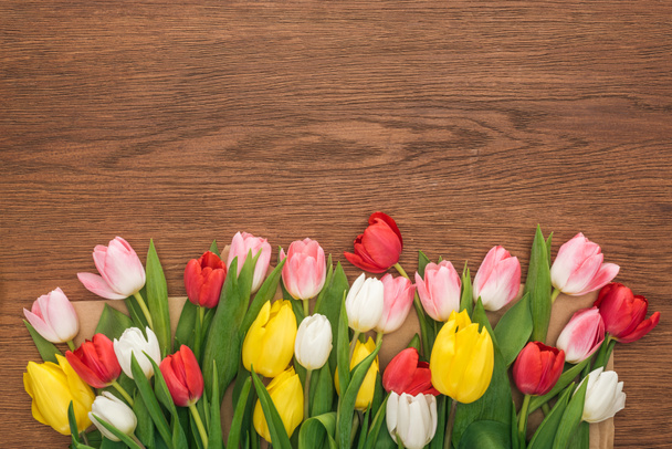 top view of colorful tulips on wooden background - Zdjęcie, obraz