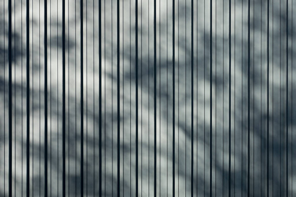 grau gefaltetes Titanblechdach mit Schlagschatten vom Baumhintergrund, flacher Hintergrund Foto-Textur - Foto, Bild