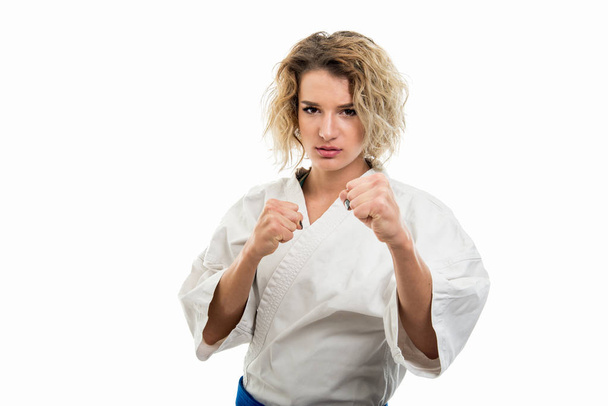 Retrato de mulher vestindo uniforme de artes marciais mostrando punhos como lutar isolado em fundo branco com espaço de cópia área de publicidade
 - Foto, Imagem