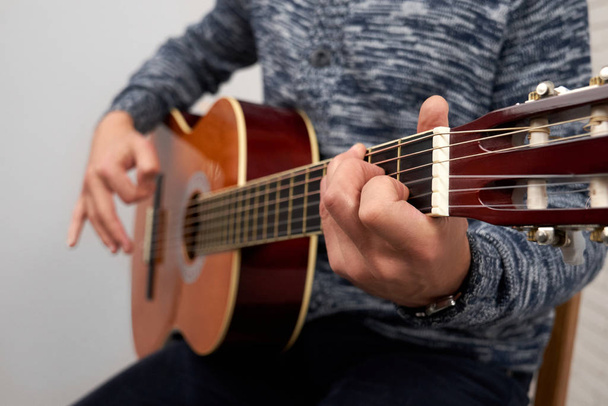 Close up of man playing acoustic guitar. - Fotó, kép