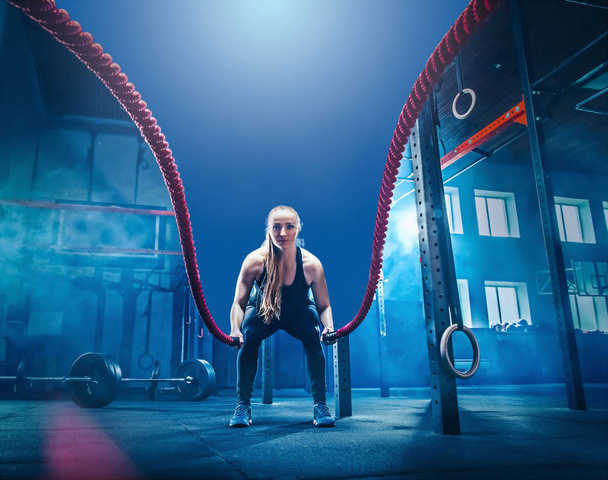 Woman with battle rope battle ropes exercise in the fitness gym. - Foto, Bild