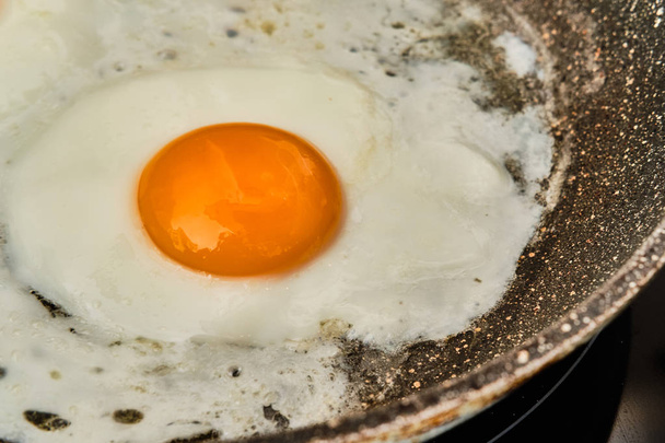 Cocinar un huevo frito en la sartén
 - Foto, imagen