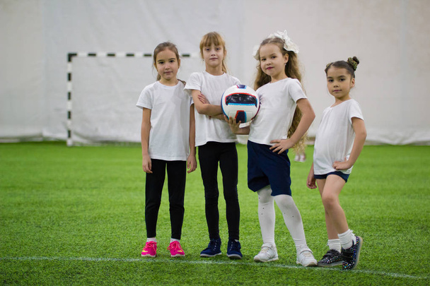 Kinder, die drinnen Fußball spielen. Fußballmannschaft besteht aus vier Mädchen - Foto, Bild