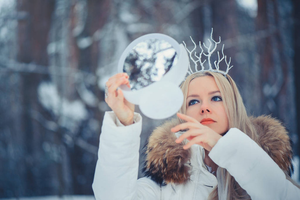 Mulher da Beleza de Inverno. Menina modelo de moda bonita com penteado de neve e maquiagem na floresta de inverno. Maquiagem festiva e manicure. Rainha de Inverno com neve e penteado de gelo
. - Foto, Imagem