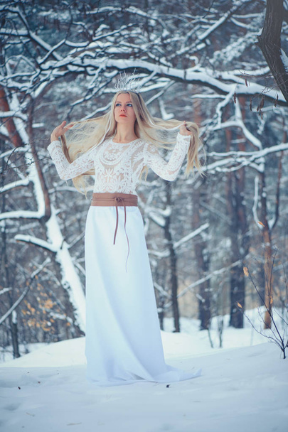 Mujer Bella de Invierno. Hermosa chica modelo de moda con peinado de nieve y maquillaje en el bosque de invierno. Maquillaje festivo y manicura. Reina de invierno con peinado de nieve y hielo
. - Foto, imagen