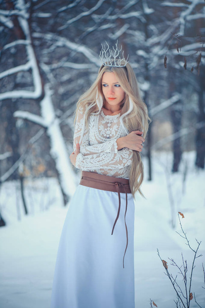 Téli szépségápolási nő. Csodálatos divat modell lány hó frizura és smink téli erdőben. Ünnepi smink és manikűr. Télen királyné a hó és a jég frizura. - Fotó, kép