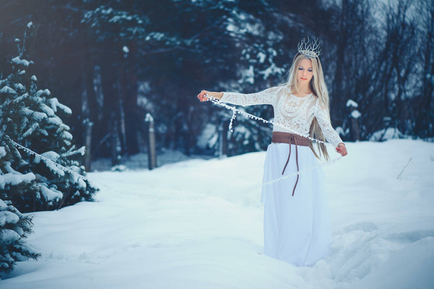 Winter schoonheid vrouw. Prachtige fashion model meisje met sneeuw kapsel en make-up in het forest van de winter. Feestelijke make-up en manicure. De koningin van de winter met sneeuw en ijs kapsel. magie - Foto, afbeelding