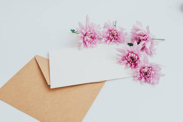 A postcard with a craft envelope on a white background with flowers - Φωτογραφία, εικόνα