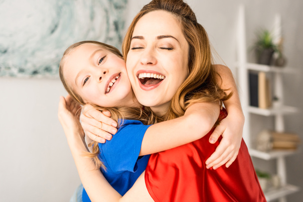 赤いマントで母親と子供を抱いてのクローズ アップ - 写真・画像