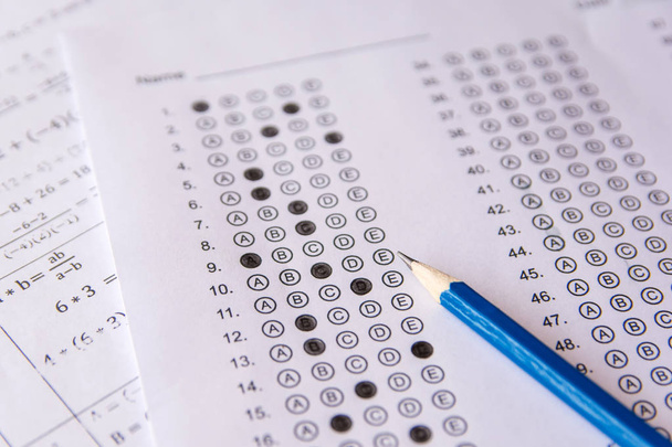 Lápiz en hojas de respuestas o formulario de prueba estandarizado con respuestas burbujeadas. hoja de respuesta de opción múltiple
 - Foto, imagen