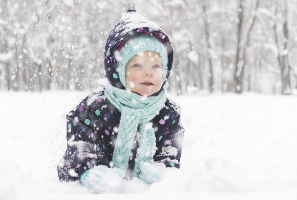 Baby in a winter jumpsuit rejoices in the first snow - Фото, зображення