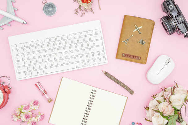 Flat lay pastel design of Valentines' day travel concept. Top view of blank notebook, wireless keyboard and mouse, passport, roses and camera on pink pastel color background. Travel in summer on pastel color background. - Foto, Bild