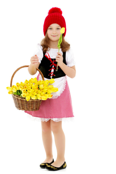 Cute little girl with a basket of flowers. - Foto, Imagen