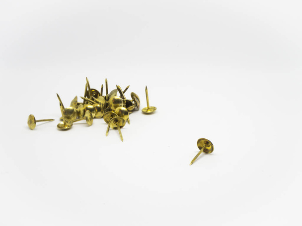 groep van gouden metalen pin op geïsoleerde witte achtergrond - Foto, afbeelding