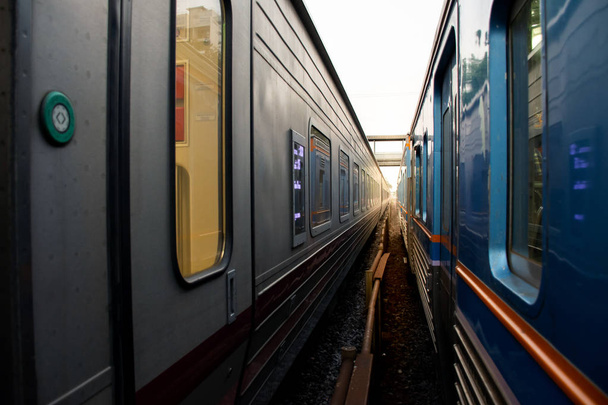 Tiivistelmä kahdesta junasta rinnakkain kiskojen kanssa
  - Valokuva, kuva