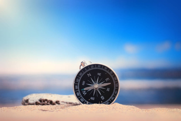Time to Travel. Idea for tourism with compass on the sand with corals on the background of the sea - Фото, зображення