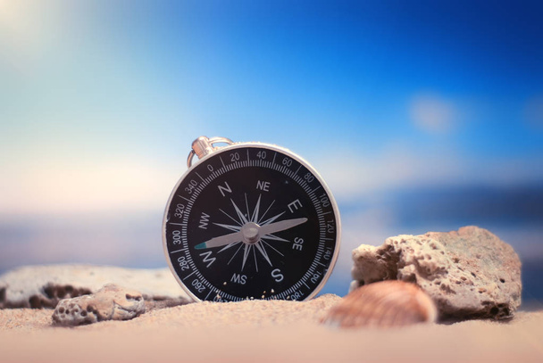 Time to Travel. Idea for tourism with compass on the sand with corals on the background of the sea - Foto, Imagem