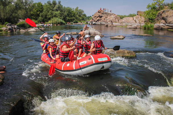 Mygiya / Ουκρανία - 22 Ιουλίου 2018: ομάδα τυχοδιώκτης απολαμβάνοντας νερό δραστηριότητα του rafting στο ποταμό Bug Νότια Ουκρανία. Το ποτάμι είναι δημοφιλής για τη θέα της γραφικό χαρακτήρα. - Φωτογραφία, εικόνα