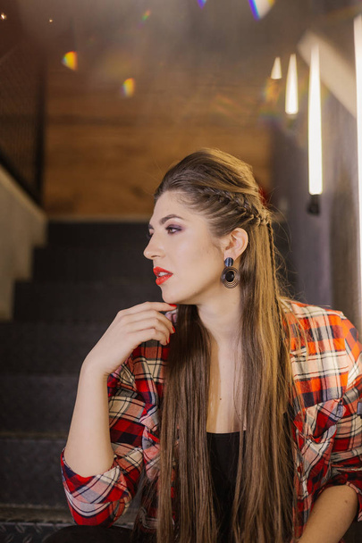 Krásná a sexy dívka pózuje fotografka na černé železné schody s lampami v kavárně. - Fotografie, Obrázek