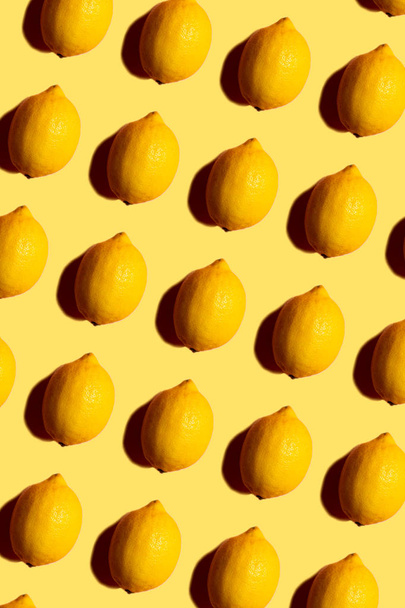Abstract pattern with lemons on yellow background - Foto, afbeelding
